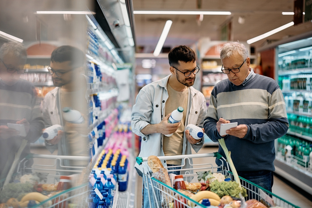 A companion helping an older man with the weekly grocery shop
