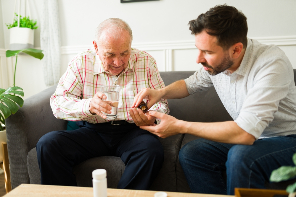 A companion helping a gentleman with a medication reminder