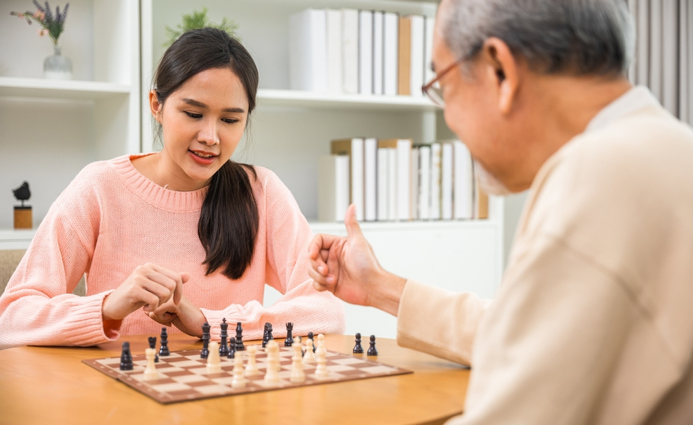 A companion enjoying a quiet game of chess with an older gentleman